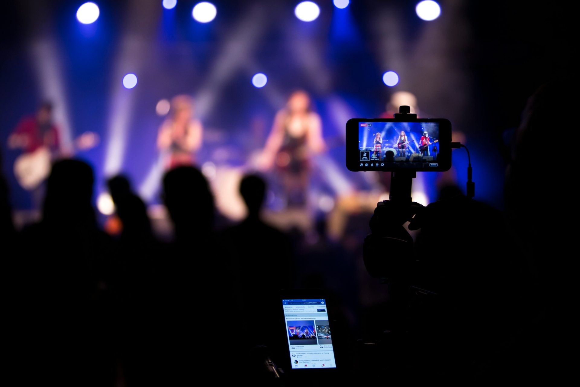 des gens prenant des vidéos pendant un concert